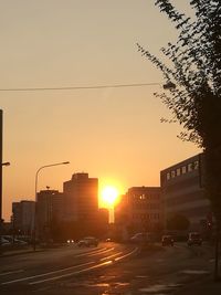 Road in city against sky at sunset