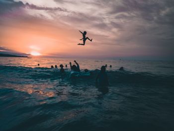 Silhouette birds flying over sea