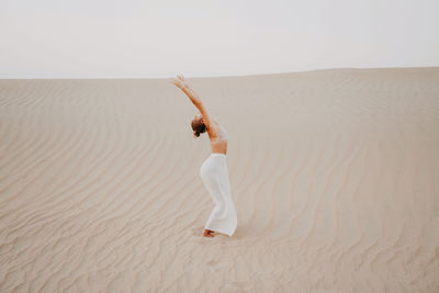 Woman in the desert with arms raised