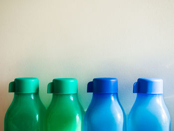 Close-up of blue bottles on table against wall