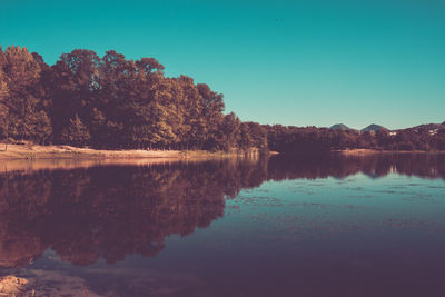 Scenic view of lake against clear blue sky