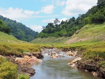 Scenic view of waterfall against sky