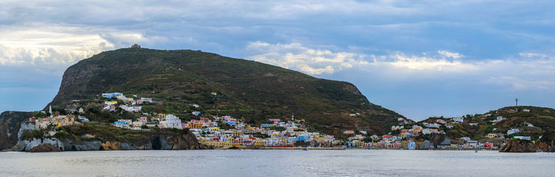 Scenic view of sea by buildings in town against sky