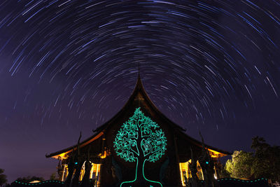 Low angle view of illuminated building against sky at night