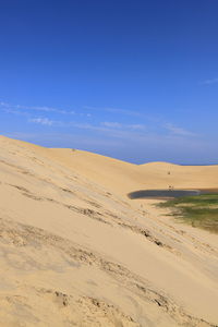 Scenic view of desert against blue sky