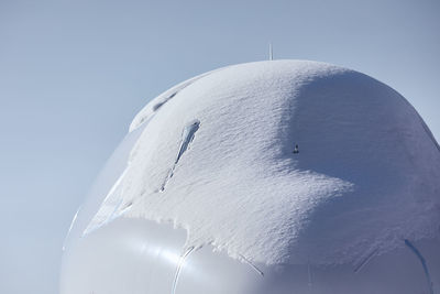 Snow covered cockpit of commercial airplane. close-up view of plane after snowfall