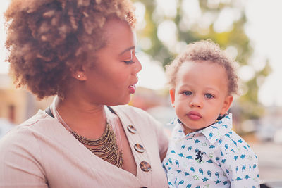 Mom holding and looking at her baby boy, baby looking at camera