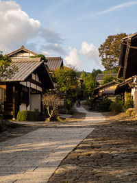 Street amidst houses and buildings against sky