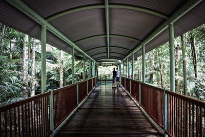 Rear view of woman walking on footbridge