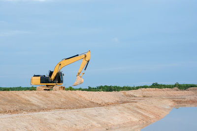 Construction site by road against sky