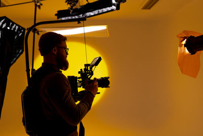 Low angle view of man holding camera