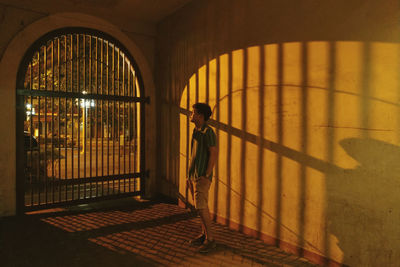 Rear view of woman standing by window in building