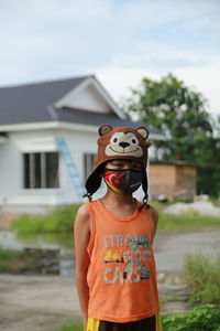 Close-up of smiling girl standing against built structure