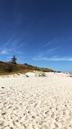 Scenic view of beach against blue sky