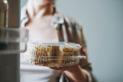 Attractive friendly brunette woman middle age in cozy cardigan eating cake 