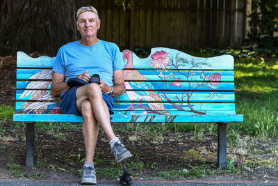 Full length portrait of a man sitting on bench