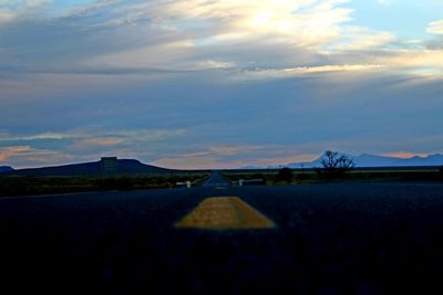 Surface level of road against sky during sunset