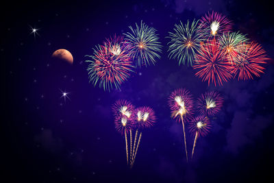 Low angle view of firework display at night