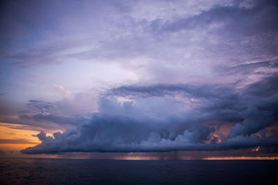 Scenic view of sea against cloudy sky at dusk
