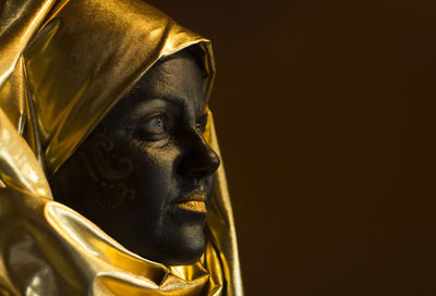 Portrait of a woman with black and gold make up, close up