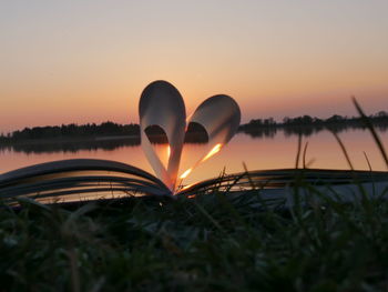 Close-up of open book against sunset sky