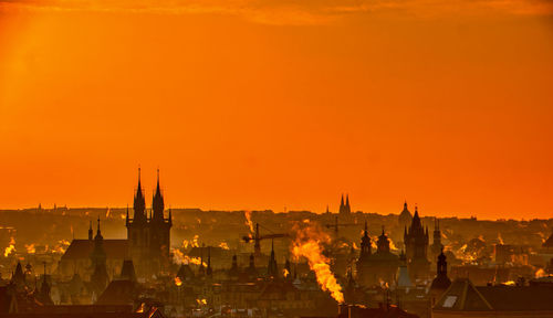 Prague silhouette at morning sunrise with red sky and chimney smoke