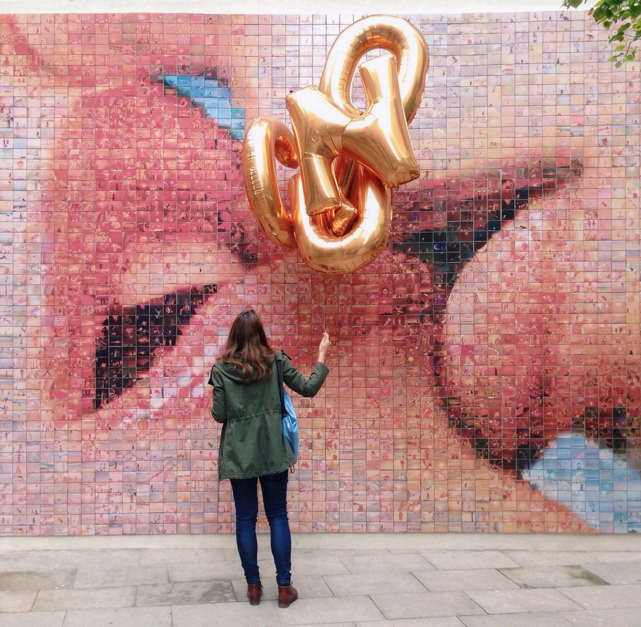 full length, built structure, building exterior, architecture, lifestyles, brick wall, casual clothing, leisure activity, wall - building feature, standing, young adult, person, front view, young women, day, outdoors, holding, three quarter length