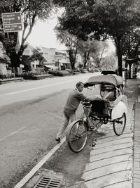 Man riding bicycle on street in city