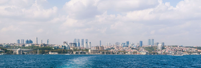 Skyscrapers in city against cloudy sky