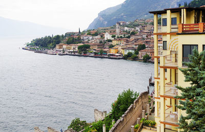 Buildings by sea against sky