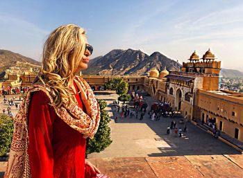 Woman standing at amber fort in city against sky