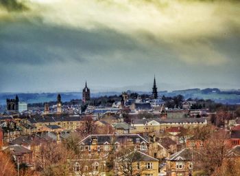 View of cityscape against cloudy sky