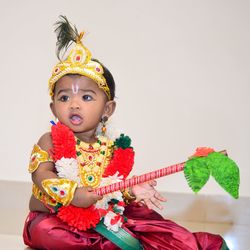 Cute girl in krishna costume playing at home