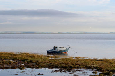 Boat moored in sea against sky