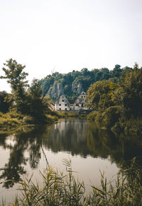 Scenic view of lake by trees against clear sky