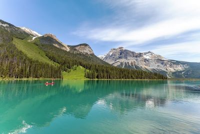 Scenic view of lake by mountains against sky