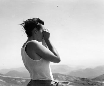 Woman standing on beach against clear sky