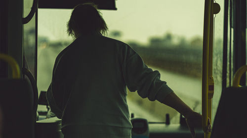Rear view of man standing by train window