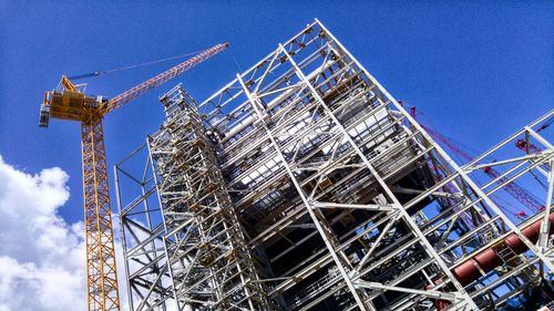 Low angle view of crane against blue sky