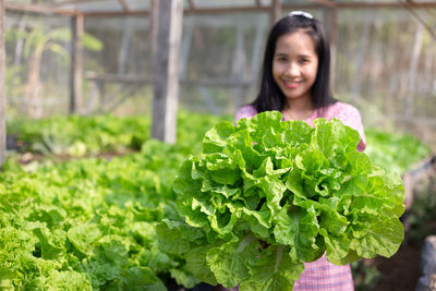 Portrait of young woman holding food outdoors