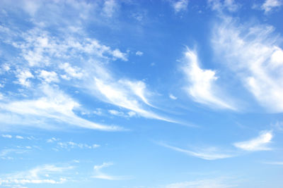 Low angle view of sunlight streaming through clouds