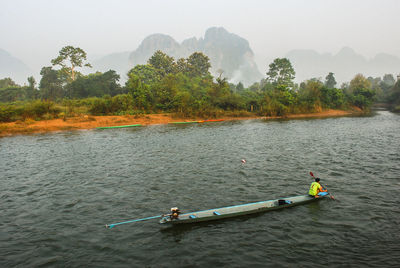 People enjoying in river against sky