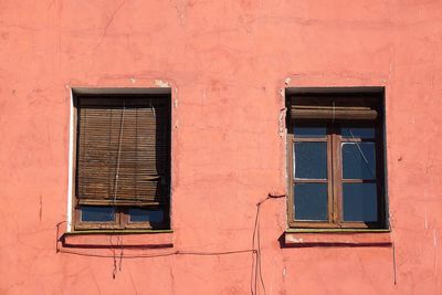 Window on the red facade of the house in the city