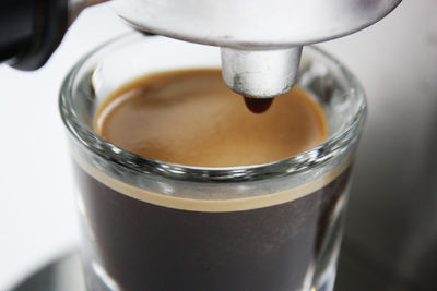 Close-up of pouring coffee in glass at cafe