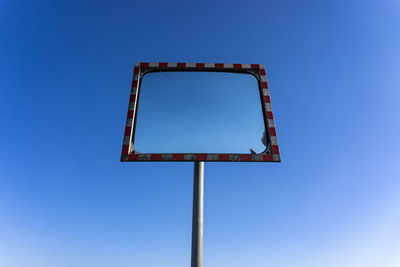 Low angle view of sign against clear blue sky