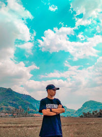 Man standing on field against sky