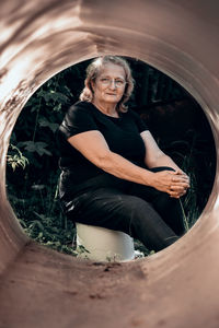 Portrait of elderly woman in glasses close-up on natural background. sunset light on face of senior