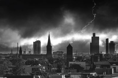 Panoramic view of buildings in city against storm clouds