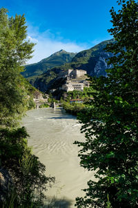 River flowing against houses and mountains