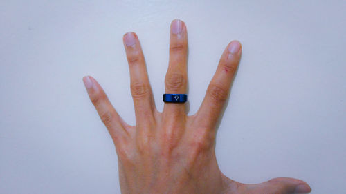 Cropped hand touching white wall